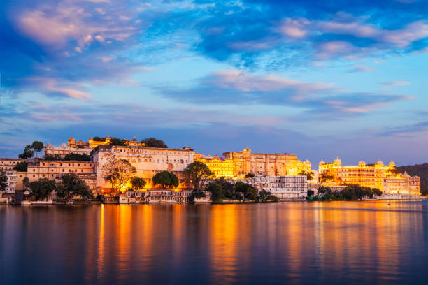 Rajasthan indian tourist landmark - Udaipur City Palace complex in the evening twilight with dramatic sky - panoramic view. Udaipur, India